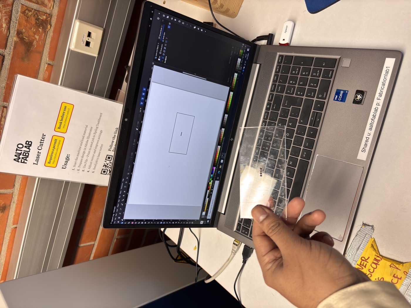 Photo of laser-cut acrylic parts on the Epilog machine bed, one piece partially snapped together