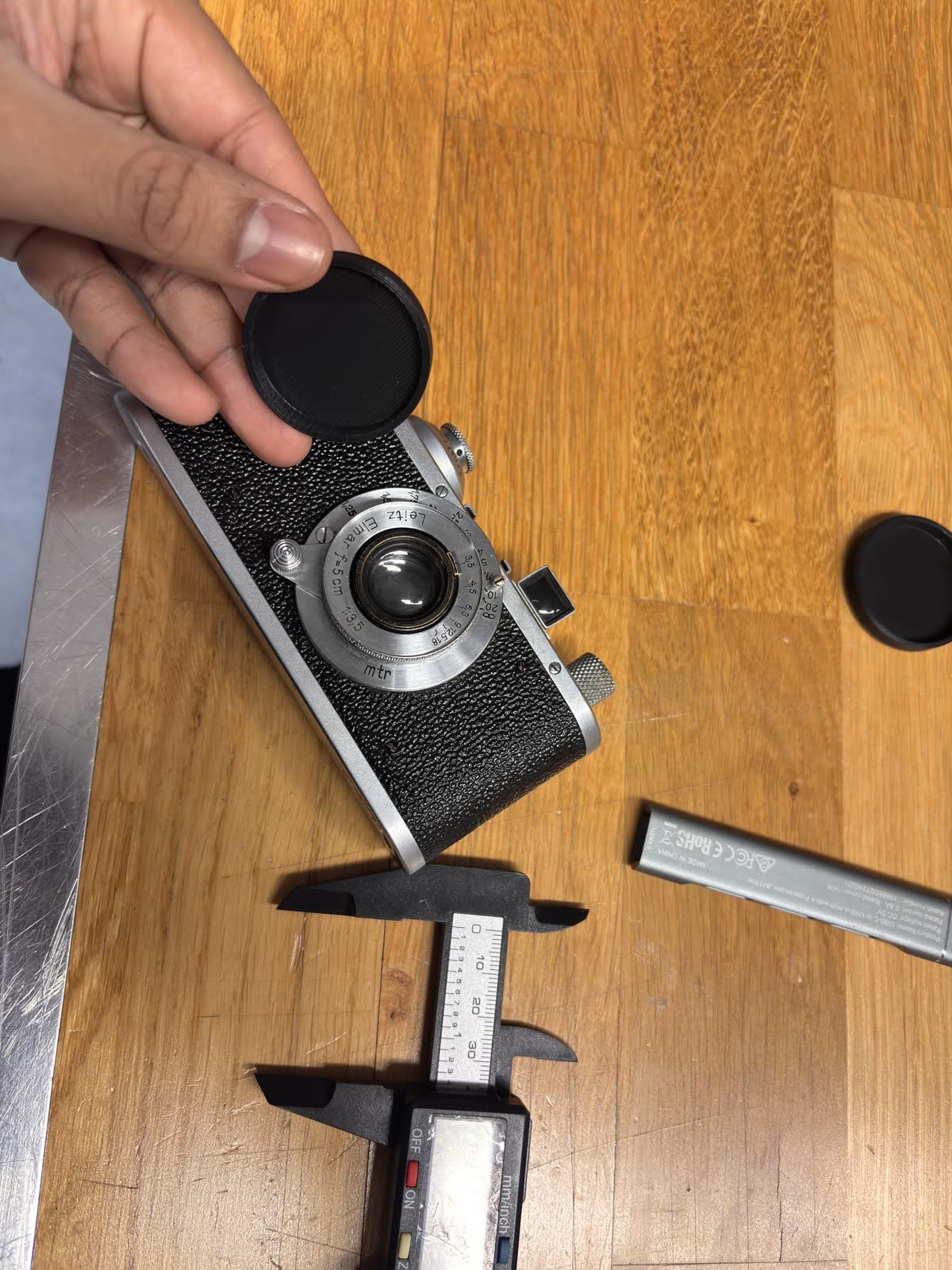 Photo of the finished 3D-printed lens cap sitting flush on the film camera lens, demonstrating a perfect fit