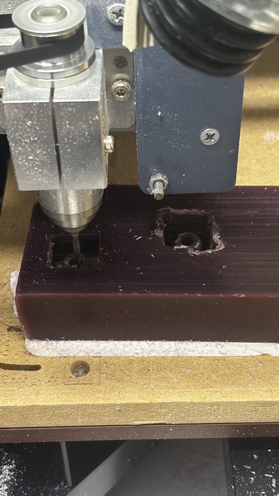 The 2 mm ball nose cutting the second cavity in the wax block, with the rough first cavity visible beside it