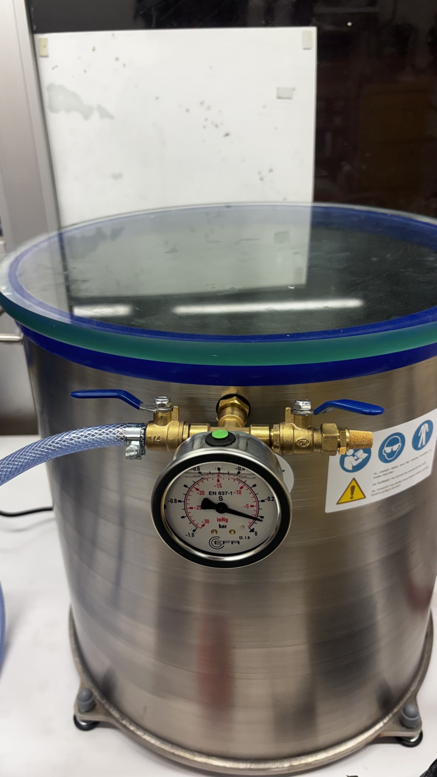 Close view of the vacuum gauge on the chamber pulling down toward negative one bar