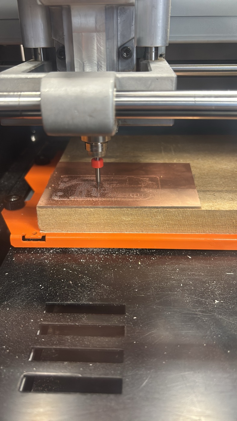 Close-up of the Roland SRM-20 mill bit cutting an isolation path on a piece of copper-clad with copper dust visible around the toolpath