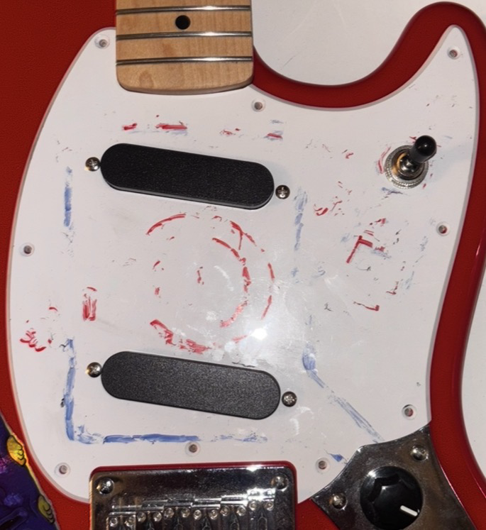 Squier Mustang body with the pickguard removed, showing the body cavity, bridge, pickup wiring and a milled PCB sitting on top of the body
