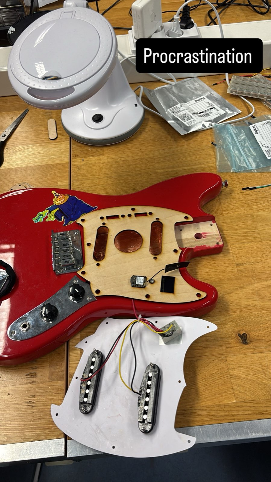 The red guitar body with the pickguard removed, showing the routed wood cavities for the pickups, controls and the new electronics pocket