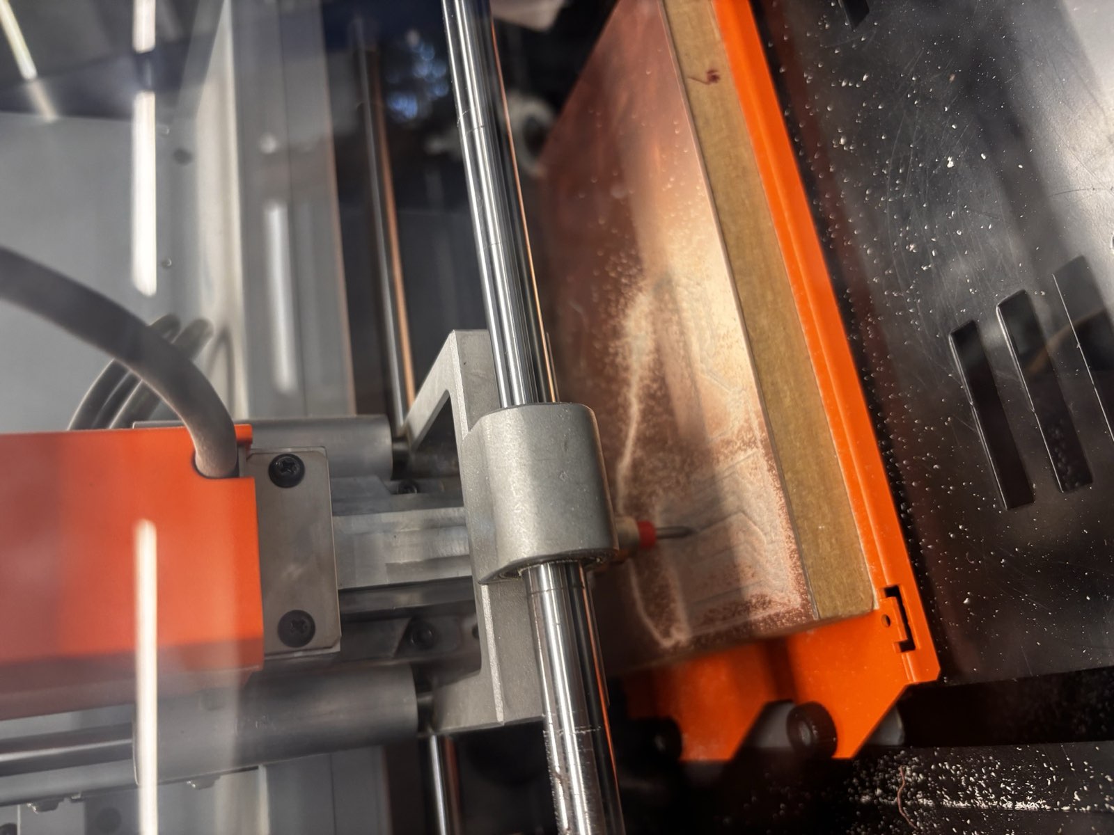 The Roland SRM-20 desktop mill cutting a copper-clad board, with copper dust over the surface